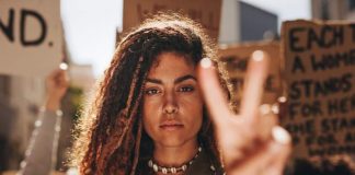 Κάνοντας λόγο για την απαγόρευση των αμβλώσεων στις ΗΠΑ woman making the peace sign with her hand