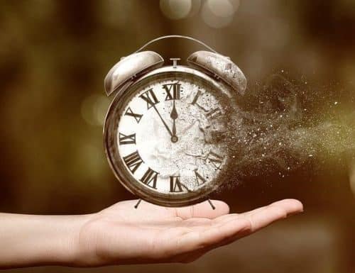 Ο χρόνος μας, το πολυτιμότερο μας αγαθό a small clock fading away with a hand holding in the air